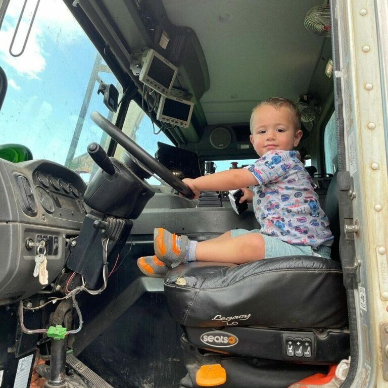 child sits in trash truck at touch a truck event in newton